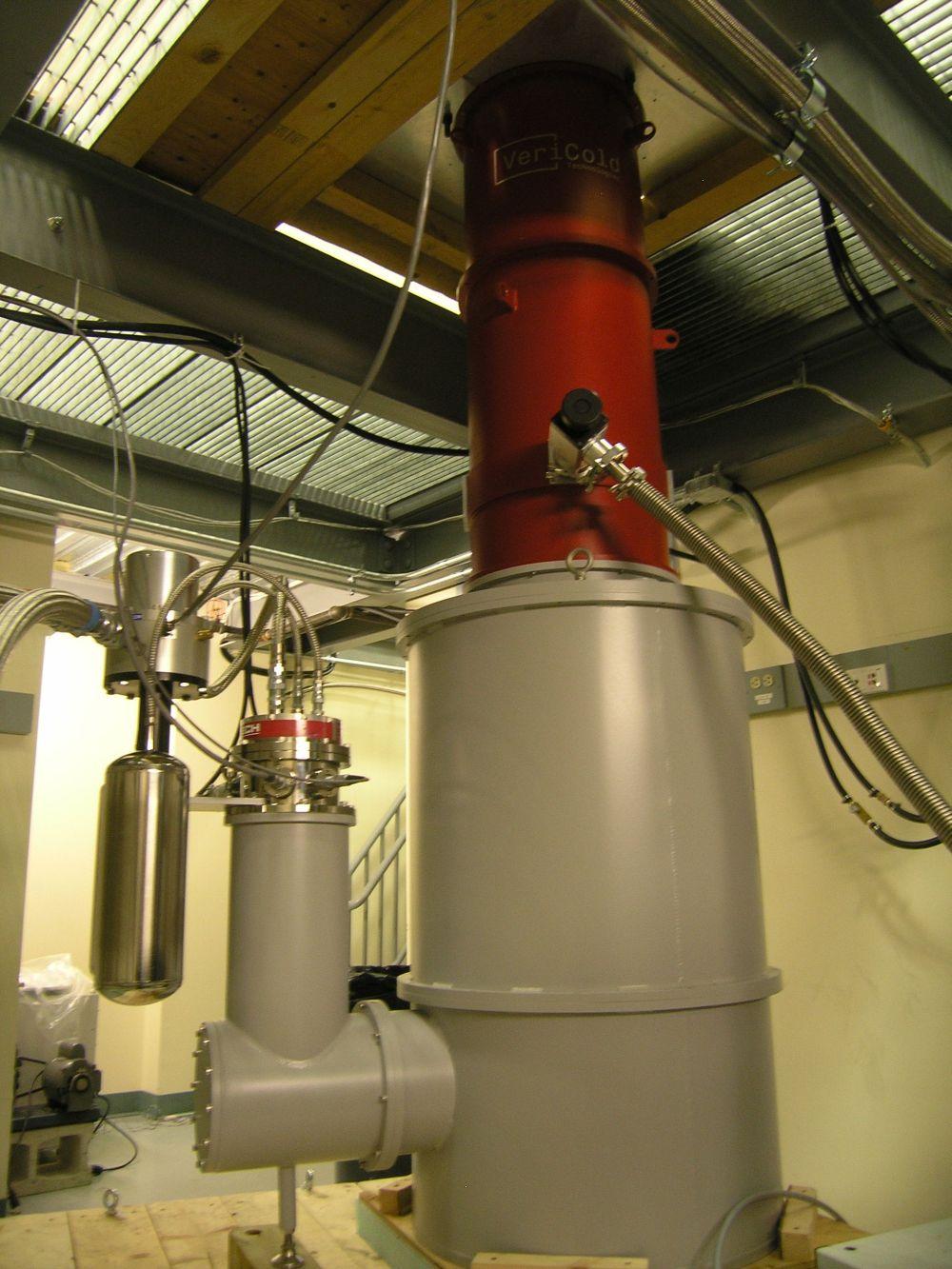 The fully assembled HAYSTAC detector is housed inside a cylindrical vacuum chamber about 10 feet tall on the lower-level of a two-story lab.
